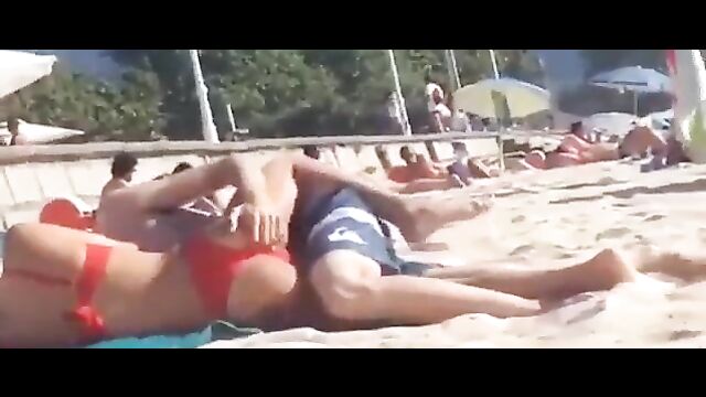 Couple having discreet sex on the beach in public - 1 image