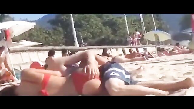 Couple having discreet sex on the beach in public