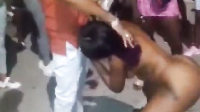 Guy receiving blow job from a naked stripper in public at a Jamaican club party - 1 image