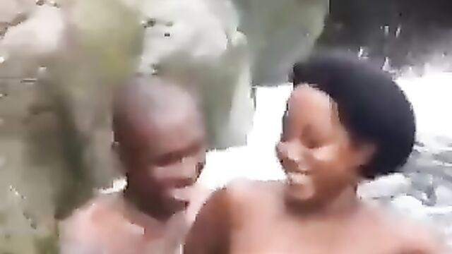 Topless ebony whore with naked breasts having fun with her boyfriend in a waterfall - 2 image