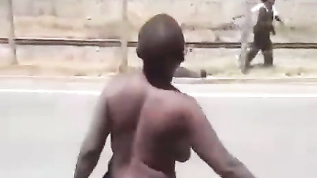 Half naked woman with big breasts protesting in public on the road in South Africa - 1 image
