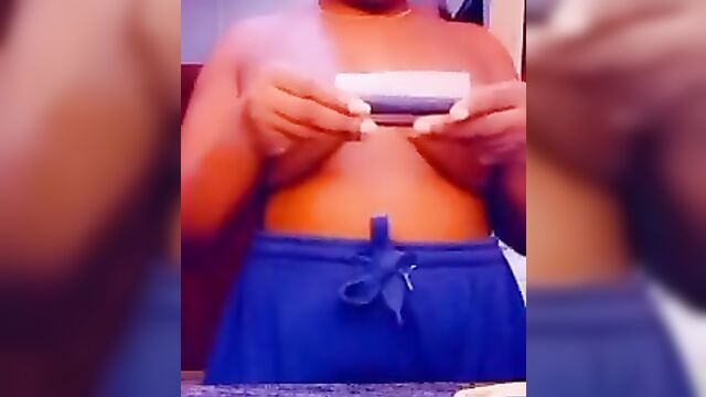 Ebony babe with naked breasts caught rolling weed on camera - 1 image