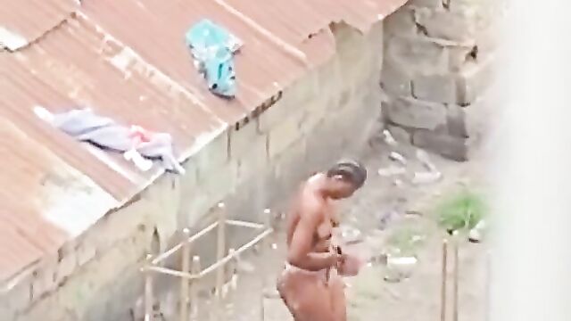 Naked African queen caught bathing outside in public - 1 image