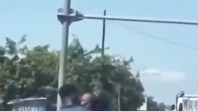 African couple making out in public on a bike - 1 image