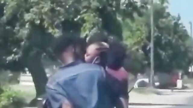 African couple making out in public on a bike - 3 image