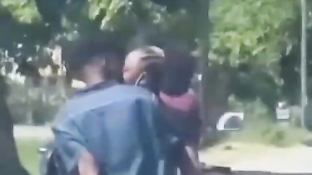 African couple making out in public on a bike - 4 image